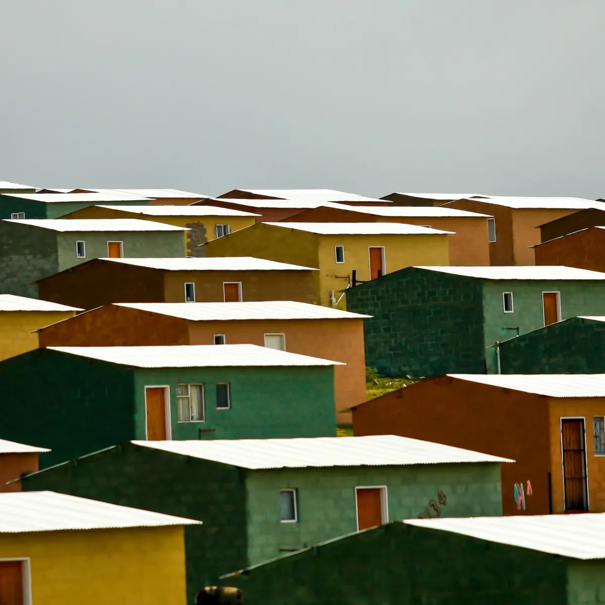 Rows of small houses in a cluster with simple pitched roofs