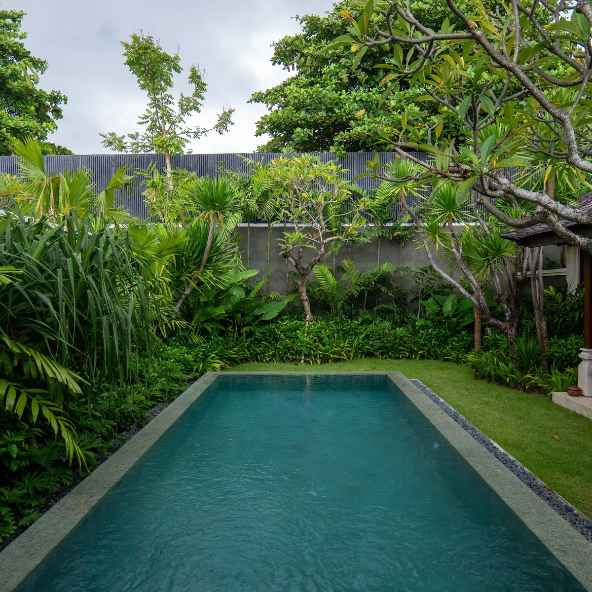 A long pool in a tropical garden beside a villa