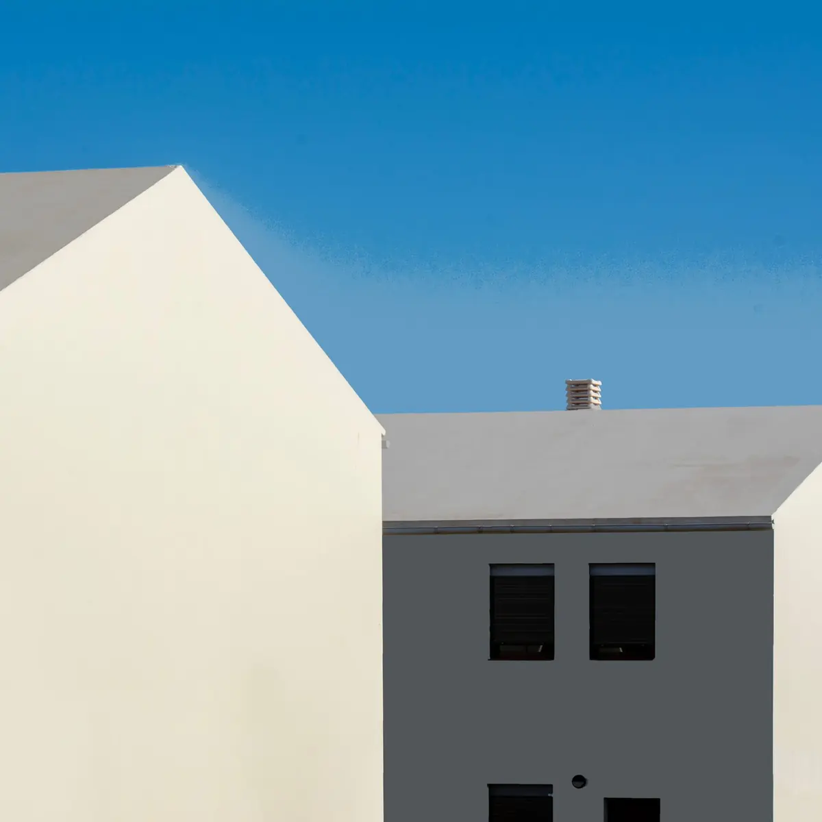White gable rooflines against a clear blue sky