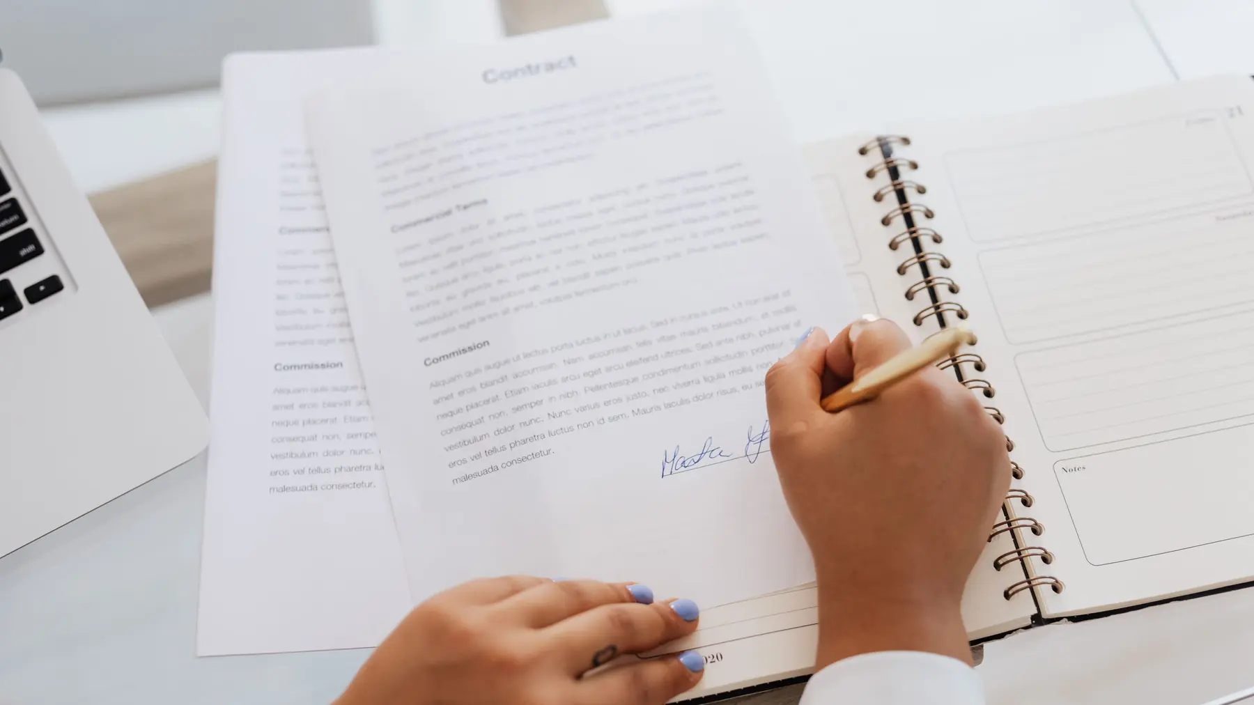 Hands reviewing printed documents and a notebook on a desk